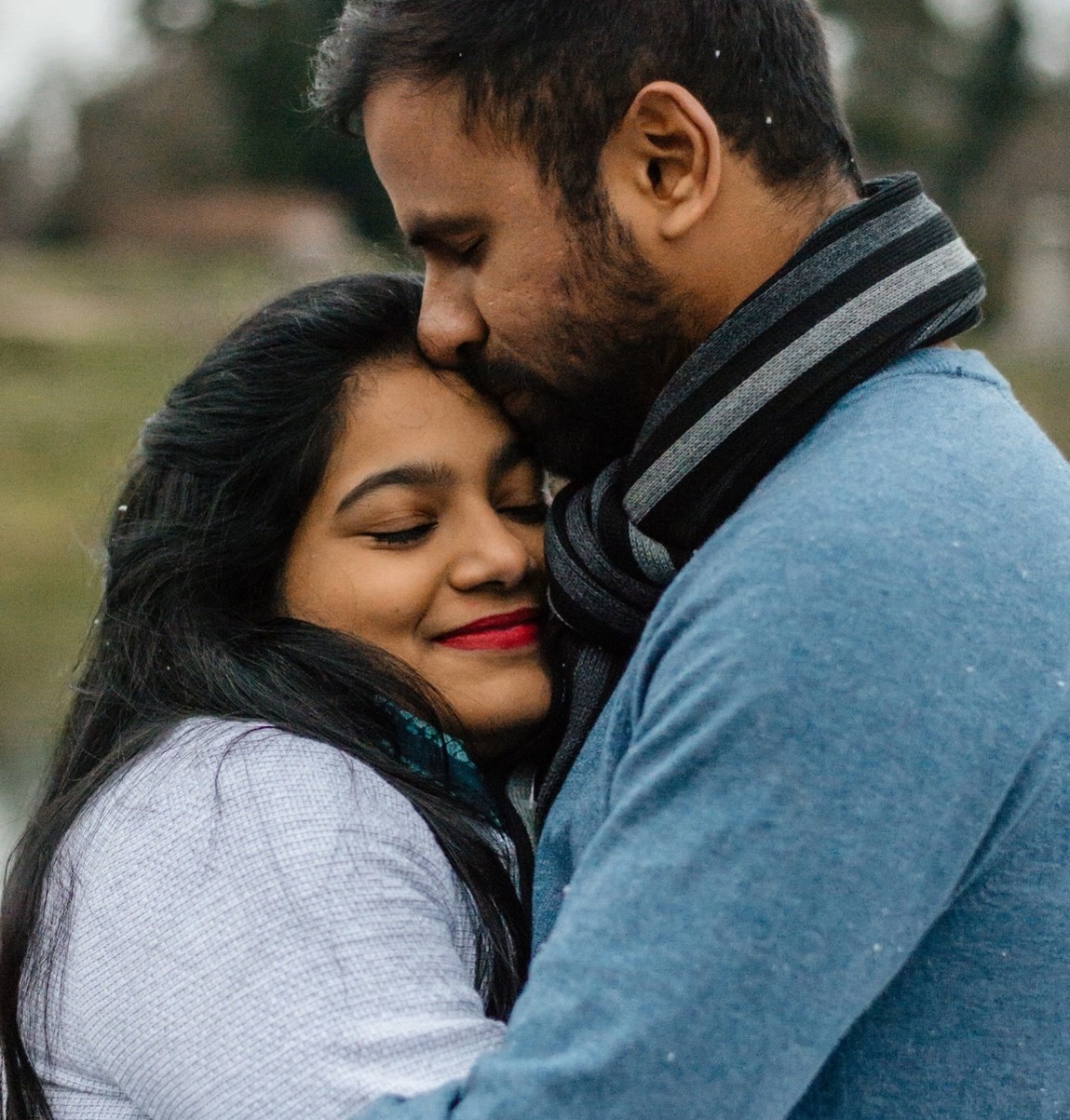 a man and woman hugging one another and smiling