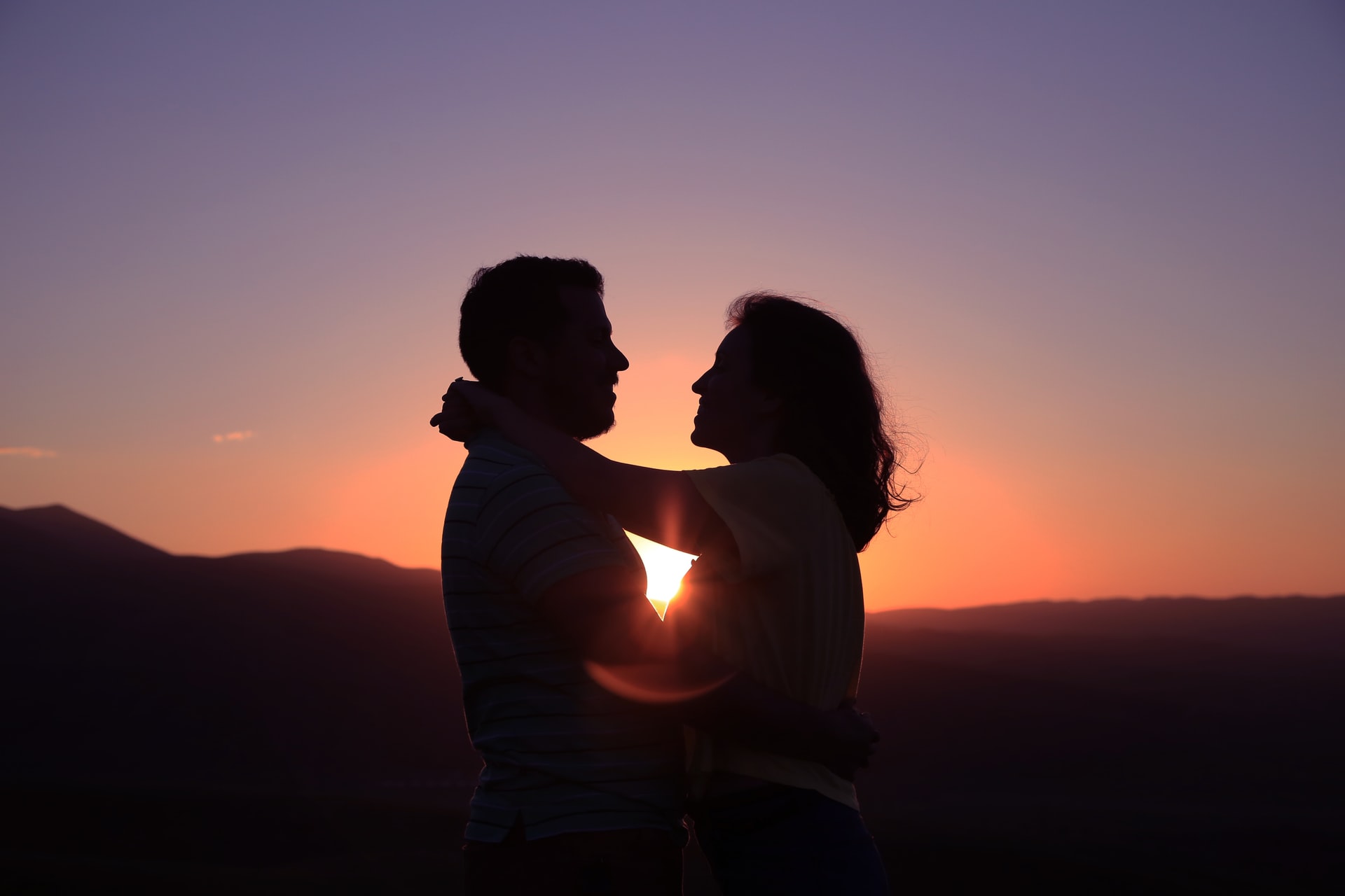 A couple embraces at sunset