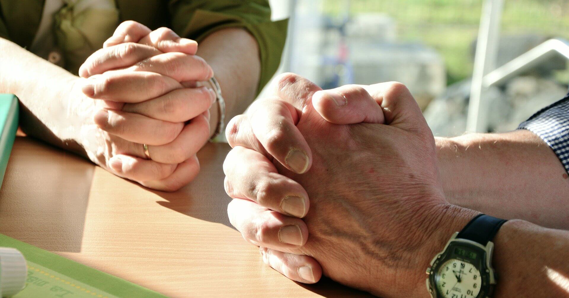 A close-up image of a couple’s praying hands