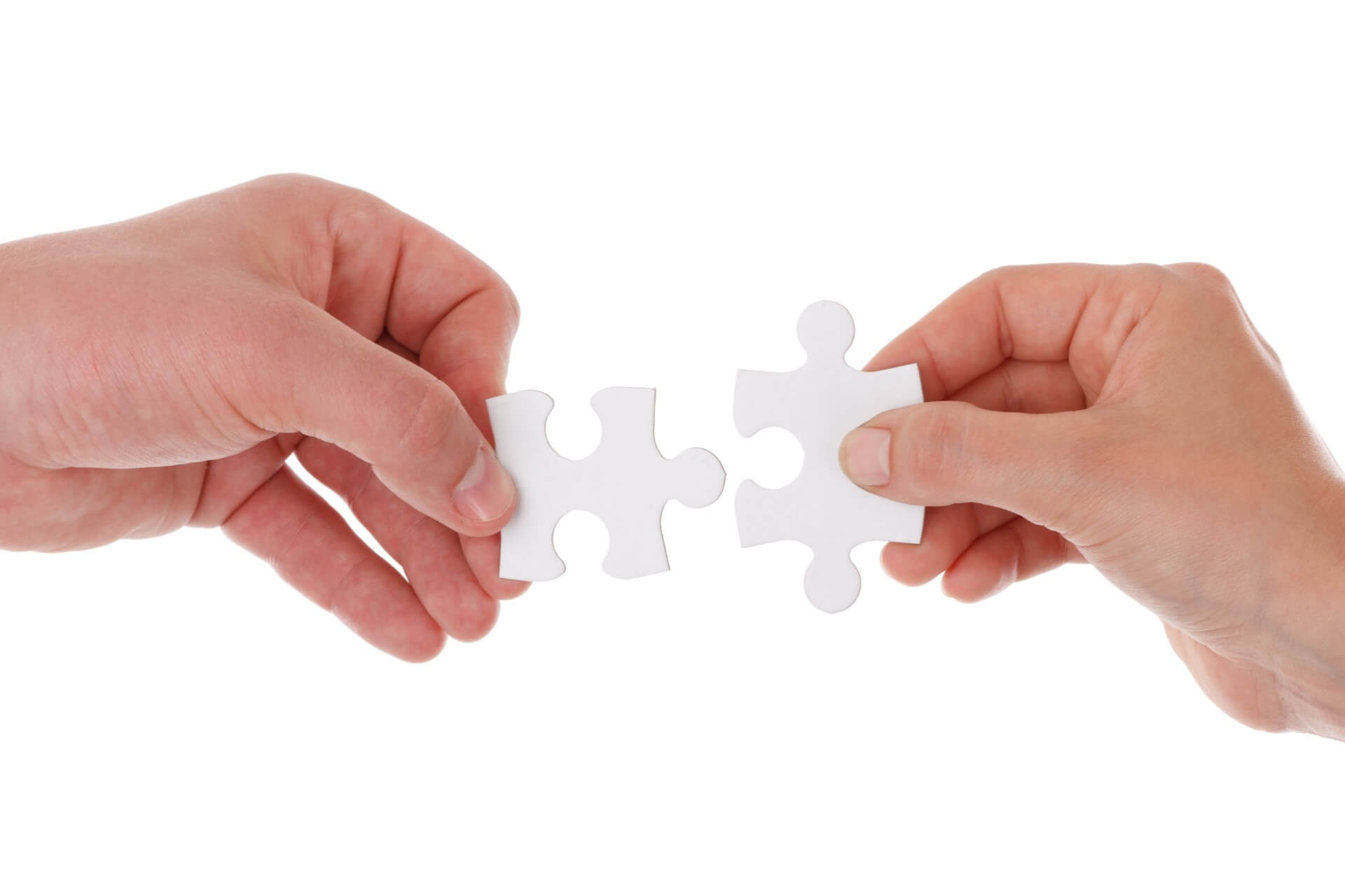 Two hands holding connecting puzzle pieces