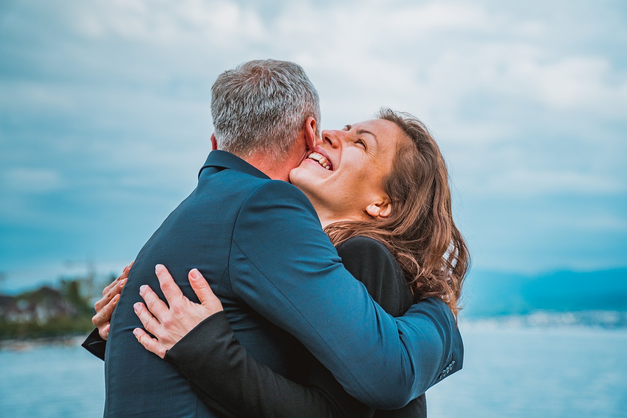 a happy couple hugging in front of a nature background