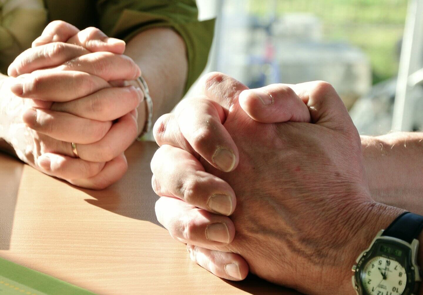 A close-up image of a couple’s praying hands