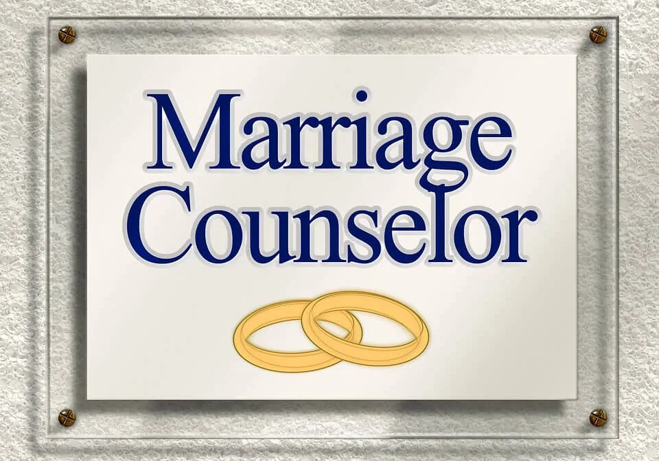 A sign with the words “Marriage Counselor” and two golden rings