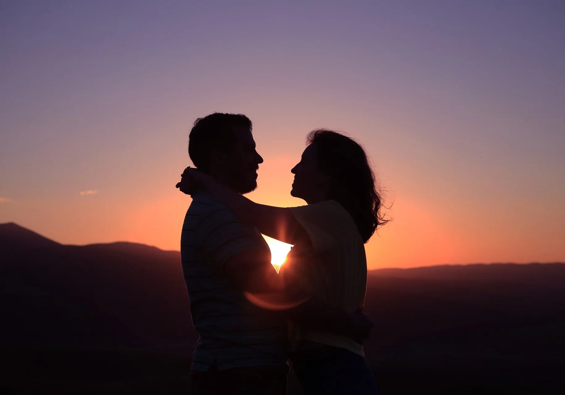A couple embraces at sunset